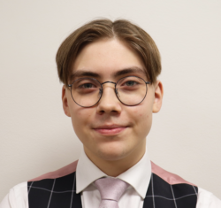 Varapuheenjohtaja Patrik Wilska on laittanut päälleen kauluspaidan ja silmälasit. Patrik katsoo kameraan.